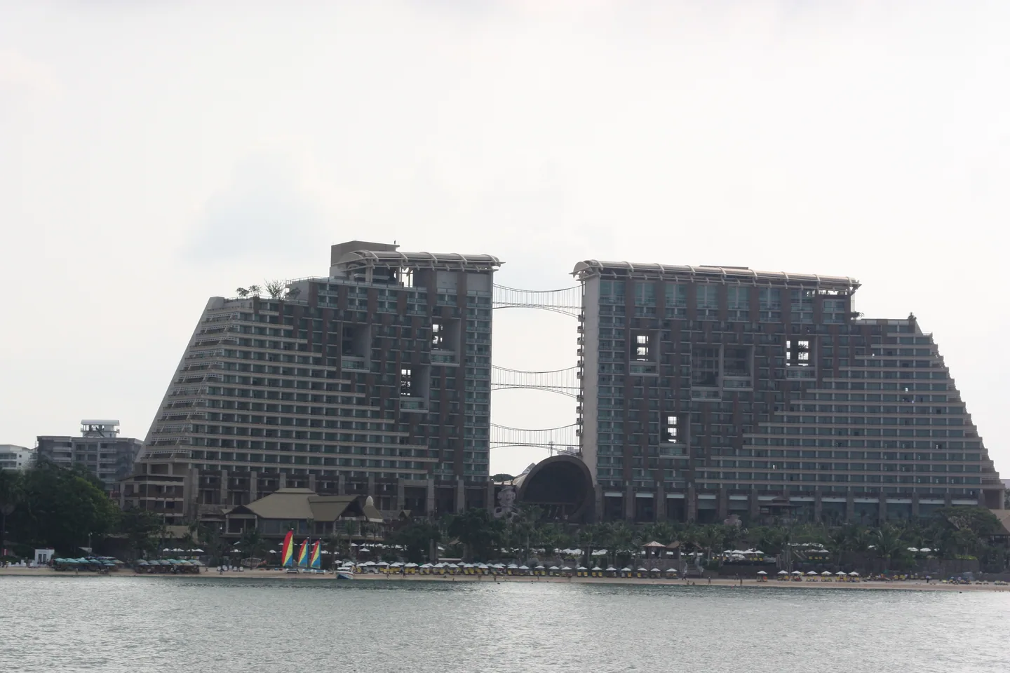 The twin stepped towers of Centara Grand Mirage Beach Resort, viewed across the water.